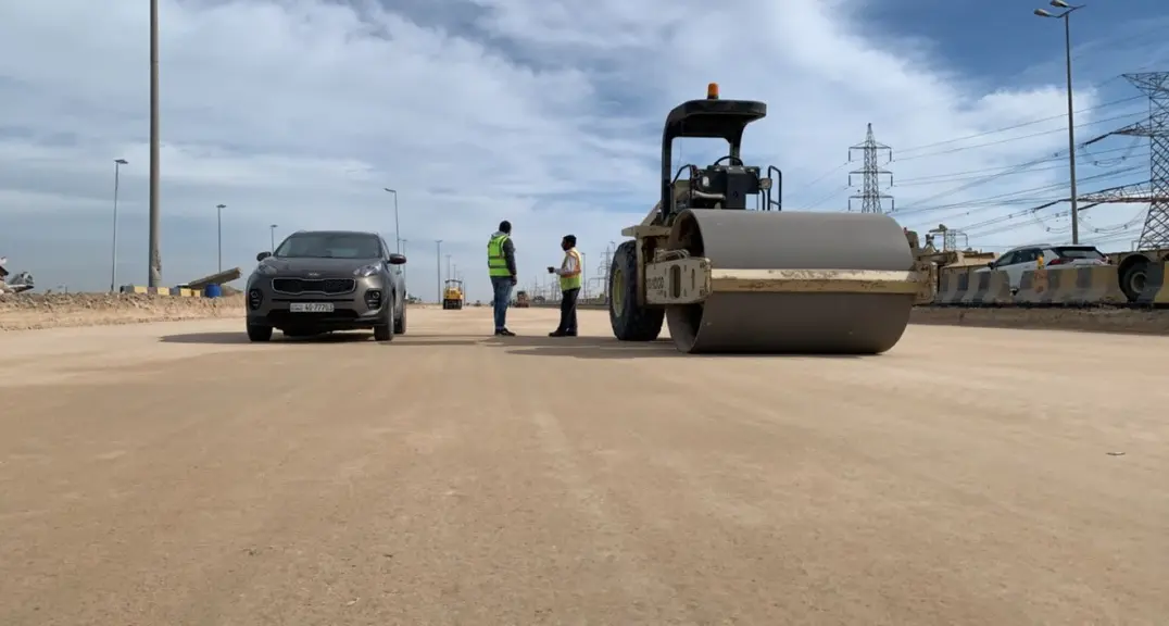 Road roller and site team on a roadworks area in Kuwait